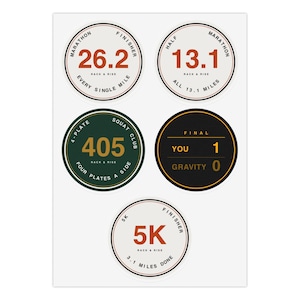 May include: A sheet of five circular stickers featuring athletic themes. Designs include Marathon Finisher 26.2, Half Marathon 13.1, 4-Plate Squat Club 405, Final You 1 Gravity 0, and 5K Finisher 5K. Each sticker displays bold text and numbers.
