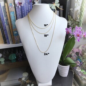 May include: Three gold chains of different lengths, 16 inches, 18 inches, and 24 inches, displayed on a white mannequin bust.