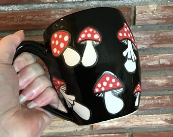 Wheel thrown and hand painted stoneware ceramic pottery mug. Glossy black with matte mushrooms. 16 oz