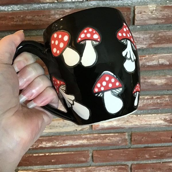 Wheel thrown and hand painted stoneware ceramic pottery mug. Glossy black with matte mushrooms. 16 oz