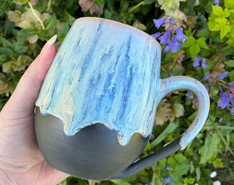 Wheel thrown and hand painted ceramic pottery stoneware mug for tea or coffee. Drippy glaze in shades of purple and blue with matte black