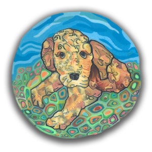 May include: A hand-painted ceramic tile featuring a cartoon doodle of a brown and white puppy with blue eyes. The puppy is lying on a bed of green, blue, orange, and pink geometric shapes against a blue background.