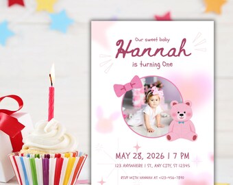 May include: A birthday invitation with the text "Our sweet baby Hannah is turning One." The invitation features a photo of a baby, a pink bow, and a pink teddy bear. A cupcake with a lit candle is in the foreground.