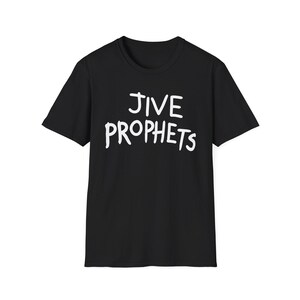 Op de afbeelding: Een zwart t-shirt met korte mouwen en de tekst JIVE PROPHETS in een wit, handgetekend lettertype op de borst gedrukt. Het kledingstuk heeft een ronde hals en een standaard pasvorm, met een eenvoudig ontwerp en opvallende witte letters.