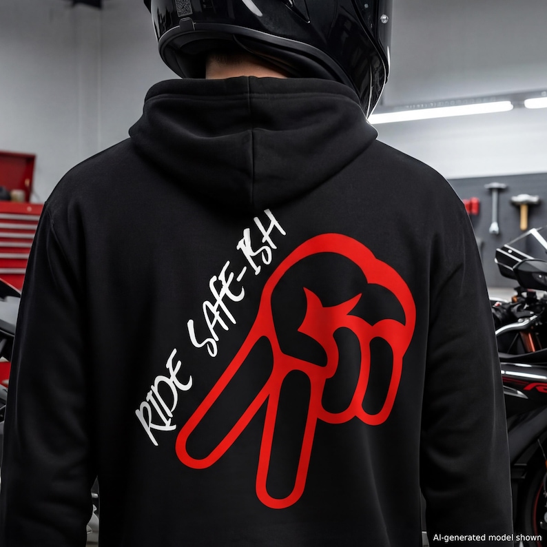 Puede incluir: Una sudadera negra con capucha que presenta un gr&aacute;fico rojo de una mano haciendo el signo de la paz en la espalda. El texto RIDE SAFE-ISH est&aacute; impreso en blanco en una fuente cursiva inclinada junto al gr&aacute;fico. La sudadera se lleva con casco.