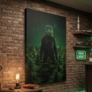 Könnte beinhalten: Ein Leinwanddruck mit einem Astronauten in einem dunklen Anzug, der in einem Feld grüner Pflanzen steht. Der Helm des Astronauten ist mit denselben grünen Pflanzen gefüllt. Das Kunstwerk wird an einer Backsteinmauer ausgestellt. Ein Neon-Schild zeigt "HIGH ORBIT".