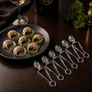 May include: A dark, round plate holds escargots, each filled with green herb butter. Silver escargot tongs are arranged nearby. A wine glass and bottle are in the background, suggesting a fine dining experience.