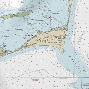 May include: A nautical chart of Cape Hatteras, North Carolina, with detailed information on depths, shoals, and navigational aids. The chart features the names of landmarks such as Hatteras Island and Diamond Shoal, with a light blue and white color scheme.