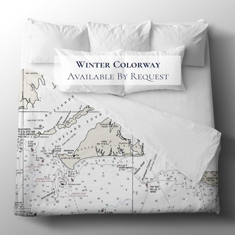May include: White bedding set with a nautical chart design. The duvet cover features a detailed map of an island with text that reads "Winter Colorway Available By Request". Includes two standard pillows and a bolster pillow.