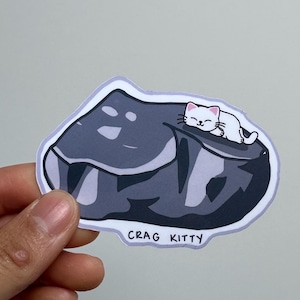 Sticker en vinyle Crag Kitty Sleeping on Boulder, laminé brillant, durable et résistant à l'eau