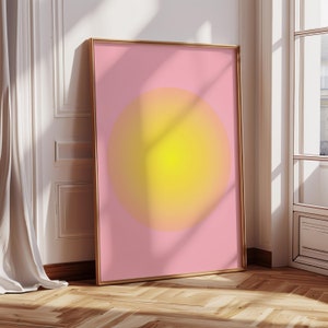 May include: A framed print with a large, yellow circle on a pink background. The circle has a gradient effect, fading from yellow to orange.