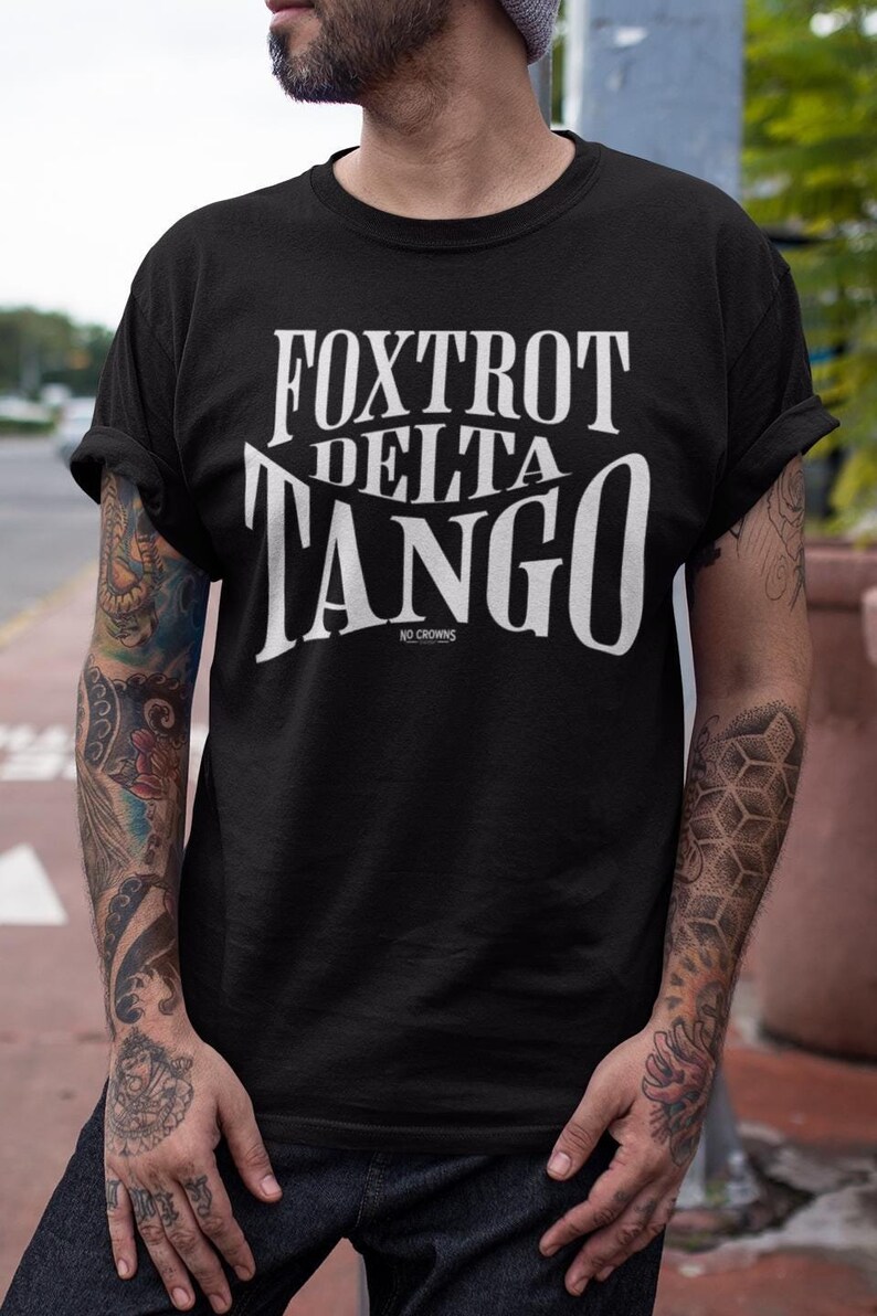 Może przedstawiać: Czarny T-shirt z białym napisem "FOXTROT DELTA TANGO NO CROWNS".