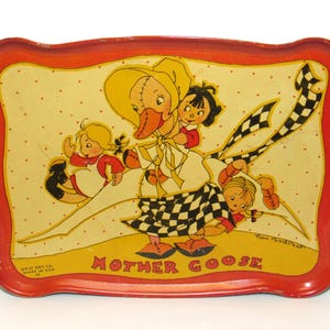 May include: A rectangular metal tray with a red scalloped border and a cream-colored center featuring a Mother Goose illustration. The graphic depicts a goose wearing a bonnet and a checkered skirt, surrounded by three children, with the text MOTHER GOOSE.