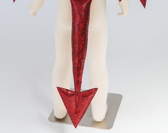 May include: Red dragon tail costume accessory with a scaly texture and a pointed tip.