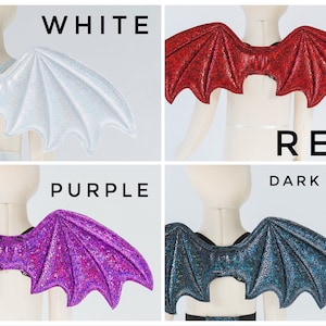 May include: Four pairs of sparkly bat wings in white, red, purple, and dark gray. The wings are attached to a mannequin torso.