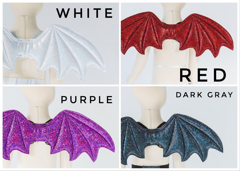 May include: Four pairs of sparkly bat wings in white, red, purple, and dark gray. The wings are attached to a mannequin torso.