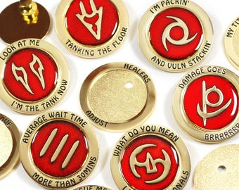 May include: A collection of gold-colored metal pins with red enamel centers. Each pin features a unique design and text, including phrases like "Busy," "Tanking the Floor," and "Damage Goes." The pins are likely for a game or hobby.