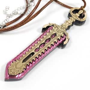May include: A wooden sword pendant necklace with a brown cord. The sword features a pink, glittery blade with gold accents and embedded pink gems. The handle has a detailed gold design.