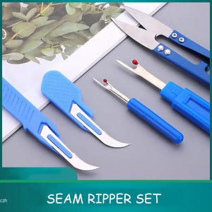 May include: A sewing tool set featuring two blue seam rippers with red safety balls, two blue-handled craft knives with curved metal blades, and a pair of blue-handled thread snips with sharp metal blades, all arranged on a flat surface.