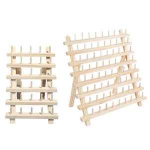 Puede incluir: Dos soportes de madera para carretes de hilo. Uno tiene forma rectangular y el otro tiene un diseño en forma de A. Ambos están hechos de madera de color claro y cuentan con filas de clavijas para sujetar los carretes de hilo. Ideal para proyectos de costura y manualidades.