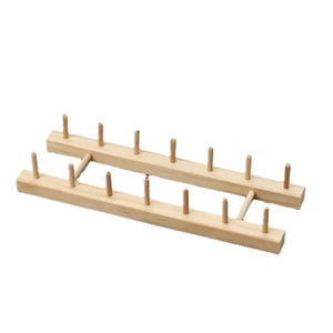 May include: Two wooden thread spool holders. Each holder is made of light-colored wood and features a series of evenly spaced pegs. The holders are connected by a small wooden bridge, designed for organizing spools of thread.