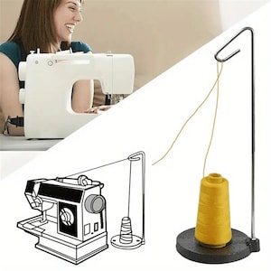 May include: A metal thread stand with a weighted circular base and a tall vertical rod featuring a curved hook at the top. A cone of yellow sewing thread sits on the base, with the thread extending upward through the hook for use with a sewing machine.