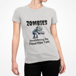 May include: Pale grey t-shirt featuring the word "ZOMBIES" in black, with a cartoon zombie graphic holding a brain. The text "Invalidating the Dead Man Test" is below the zombie.