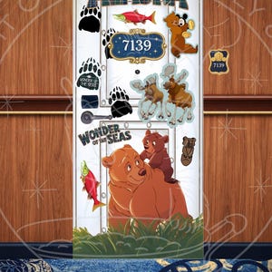 May include: A decorative door panel with an Alaska theme. The design includes the word "Alaska" in plaid lettering, cartoon bears, moose, fish, and paw prints. The number "7139" is displayed on a blue and gold plaque. The words "Wonder of the Seas" are also present.