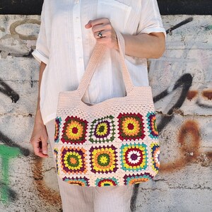 This multicolored beige, red, green, orange, blue, purple and yellow crochet pattern bag is perfect for your casual spring and summer outings.