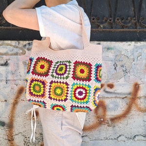 This multicolored beige, red, green, orange, blue, purple and yellow crochet pattern bag is perfect for your casual spring and summer outings.