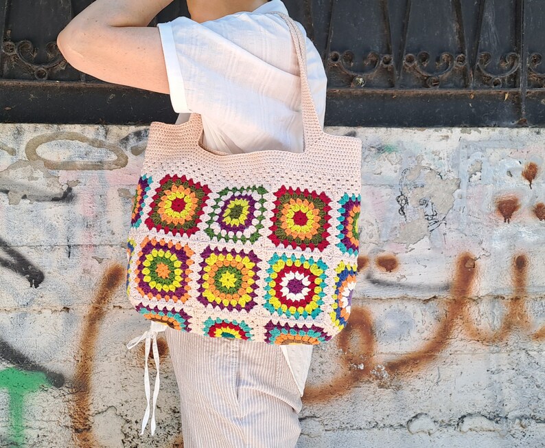 This multicolored beige, red, green, orange, blue, purple and yellow crochet pattern bag is perfect for your casual spring and summer outings.
