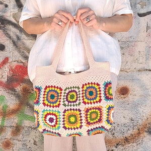 This multicolored beige, red, green, orange, blue, purple and yellow crochet pattern bag is perfect for your casual spring and summer outings.