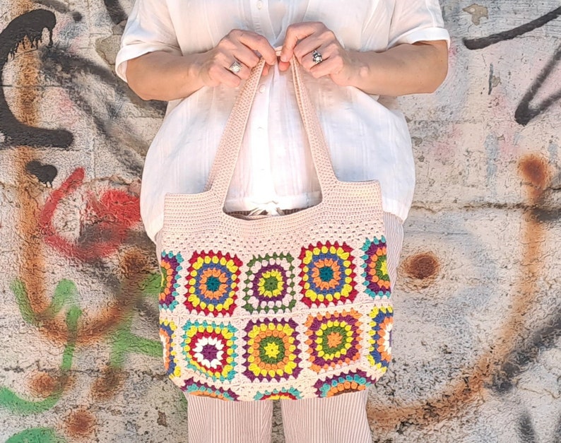 This multicolored beige, red, green, orange, blue, purple and yellow crochet pattern bag is perfect for your casual spring and summer outings.