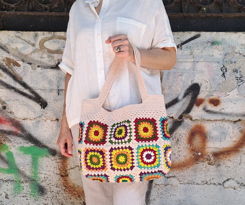 This multicolored beige, red, green, orange, blue, purple and yellow crochet pattern bag is perfect for your casual spring and summer outings.