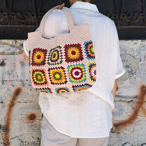 This multicolored beige, red, green, orange, blue, purple and yellow crochet pattern bag is perfect for your casual spring and summer outings.