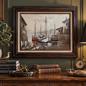 May include: An oil painting in a dark wood frame depicting a harbor scene with several boats docked between wooden structures. The artwork features a muted color palette of grays, browns, and whites, with the artist signature W. Jones in the corner.