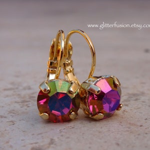 May include: Gold hoop earrings with iridescent pink and green round gemstones.