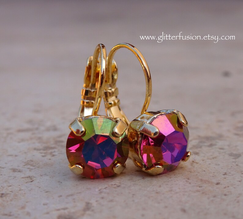 May include: Gold hoop earrings with iridescent pink and green round gemstones.