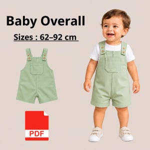 Peut inclure: Une salopette pour bébé vert sauge avec une poche avant et des bretelles à boutons, portée par un enfant avec un t-shirt blanc et des baskets blanches. Le texte indique Baby Overall Sizes : 62-92 cm. Une icône PDF rouge est visible en bas.
