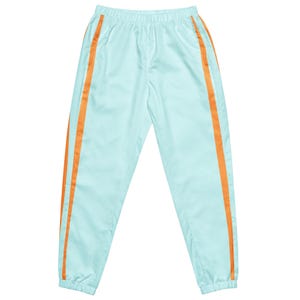 Könnte beinhalten: Hellblaue Sporthose mit orangefarbenen Seitenstreifen. Die Hose hat einen elastischen Bund und eine lockere Passform. Die orangefarbenen Streifen verlaufen vertikal an den Seiten und setzen einen Farbakzent. Die Hose ist aus leichtem Material gefertigt.