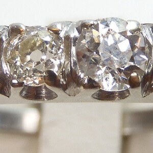 Puede incluir: Un anillo de banda de plata con cinco diamantes redondos engastados en fila.