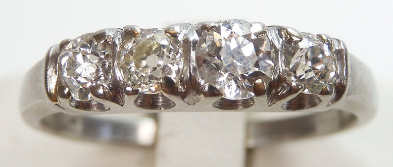 Puede incluir: Un anillo de banda de plata con cinco diamantes redondos engastados en fila.