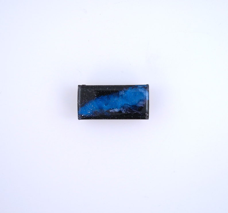 Handpainted nebula magnet set, one primarily blue and the other pink and blue covered and resin, painted in gold on the back and covered and initialled with date.