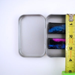 Handpainted nebula magnet set, one primarily blue and the other pink and blue covered and resin, painted in gold on the back and covered and initialled with date.