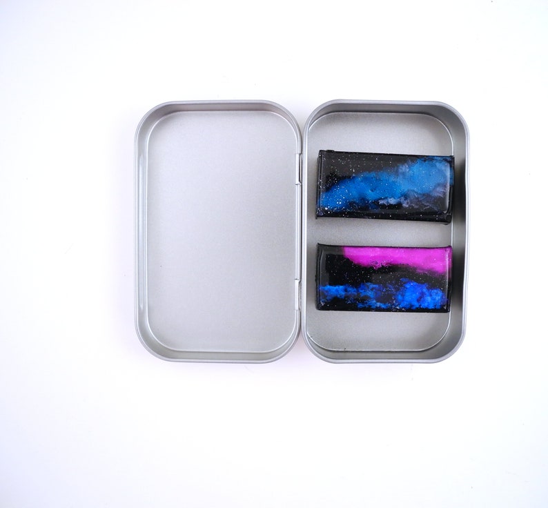 Handpainted nebula magnet set, one primarily blue and the other pink and blue covered and resin, painted in gold on the back and covered and initialled with date.