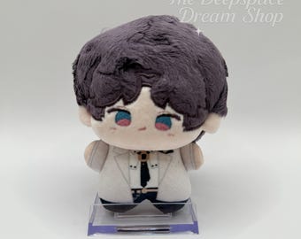 Puede incluir: Una muñeca de peluche con abrigo blanco, corbata negra y cabello morado oscuro. La muñeca tiene ojos azules y mejillas rosadas. Se exhibe sobre un soporte transparente. El texto "The Deepspace Dream Shop" está en la esquina superior derecha.