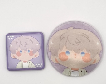 May include: Two cartoon character pins. One is square, the other is round. Both pins feature a light-haired character with blue eyes, rosy cheeks, and a green and white jacket. The square pin has white dots in the corners.