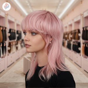 Puede incluir: Una peluca rosa con un estilo en capas, largo hasta los hombros y flequillo. La peluca tiene un aspecto suave y natural y está peinada con una ligera onda. El fondo presenta una tienda con varias extensiones de cabello.