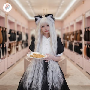 Puede incluir: Un vestido negro y blanco con cuello y mangas blancos. La persona lleva una diadema de orejas de gato con pelo negro y blanco. La peluca larga y ondulada es blanca. Se sostiene un plato de galletas en las manos.