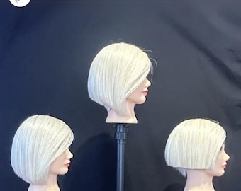 May include: Three mannequin heads with short, platinum blonde bobs. The heads are on black stands and are facing to the right.